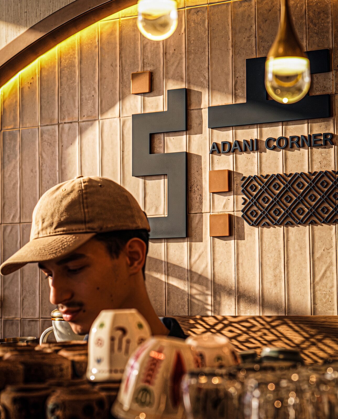 An Adani Corner team member beside the café wall